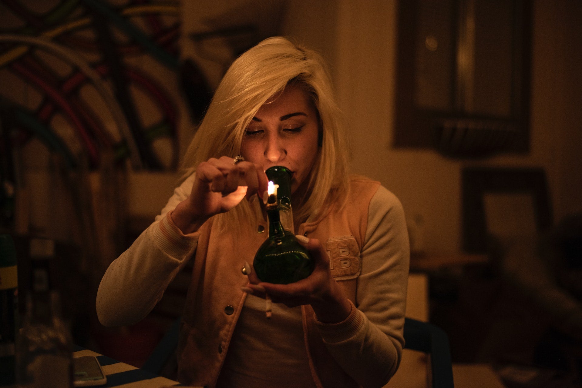 Person Smoking Tiny Bong in Apartment